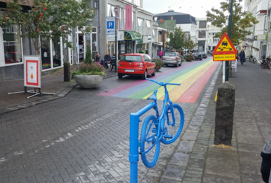 Iceland street with rainbow painted on the asphalt and bicycle gate